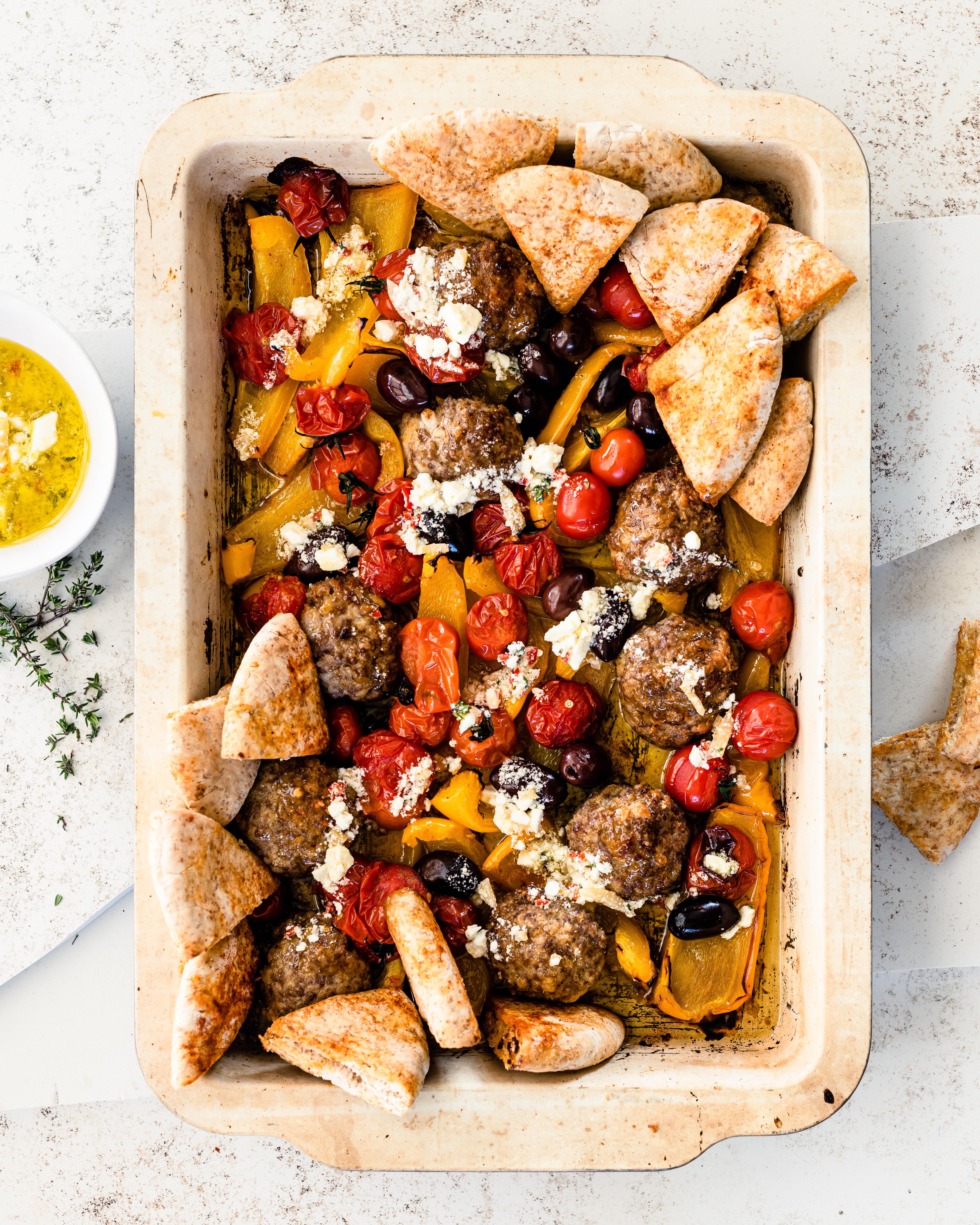 Griekse traybake met lamsgehaktburgers en frisse feta-tijmolie